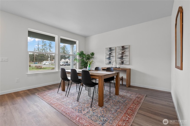 dining space with wood finished floors and baseboards