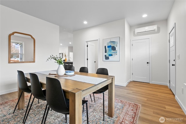 dining space with light wood-style flooring, recessed lighting, baseboards, and a wall mounted air conditioner