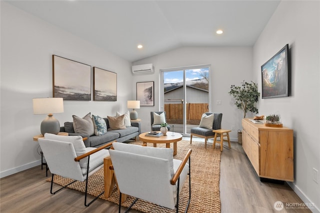 living room featuring baseboards, an AC wall unit, light wood-style floors, and vaulted ceiling