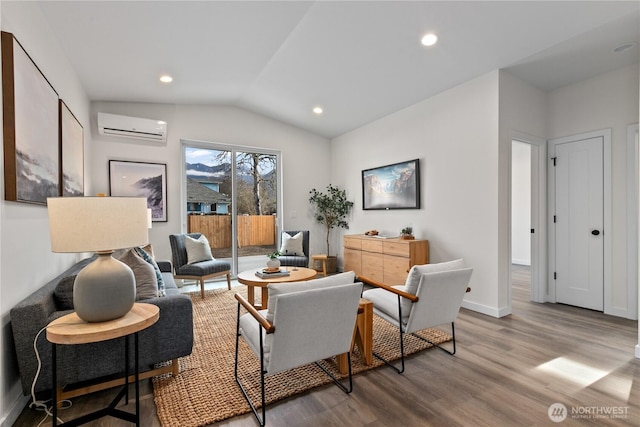 sitting room featuring a wall unit AC, wood finished floors, baseboards, recessed lighting, and vaulted ceiling