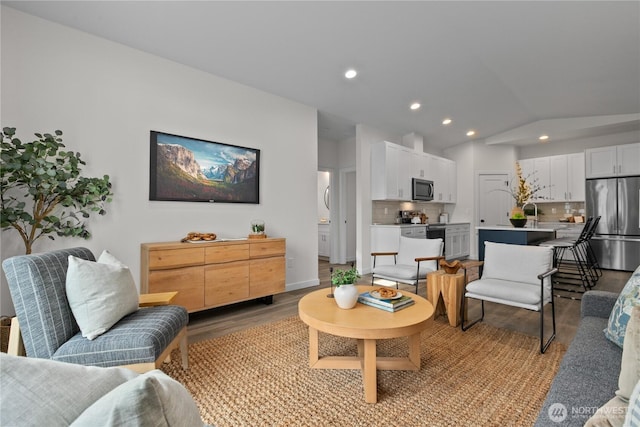 living room featuring recessed lighting, baseboards, lofted ceiling, and light wood finished floors