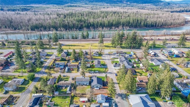 aerial view with a forest view, a water view, and a residential view