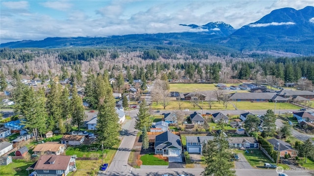 birds eye view of property with a mountain view, a residential view, and a view of trees