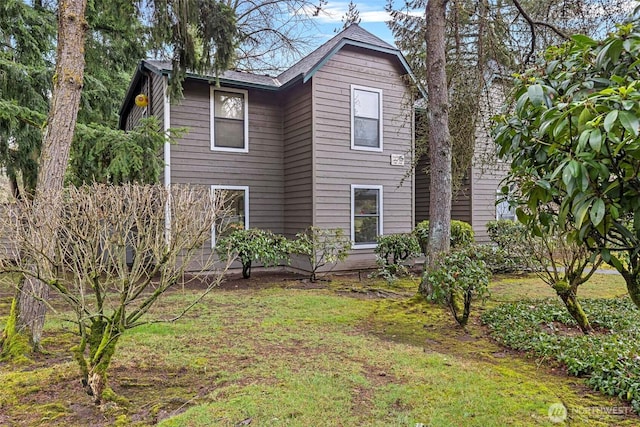 rear view of property featuring a yard