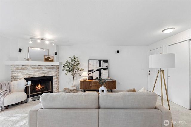 living room featuring a tile fireplace and light carpet