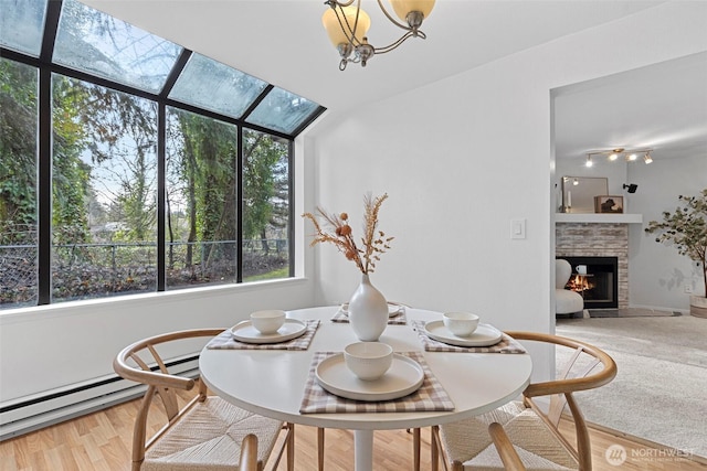 dining room featuring a fireplace, a baseboard radiator, and wood-type flooring