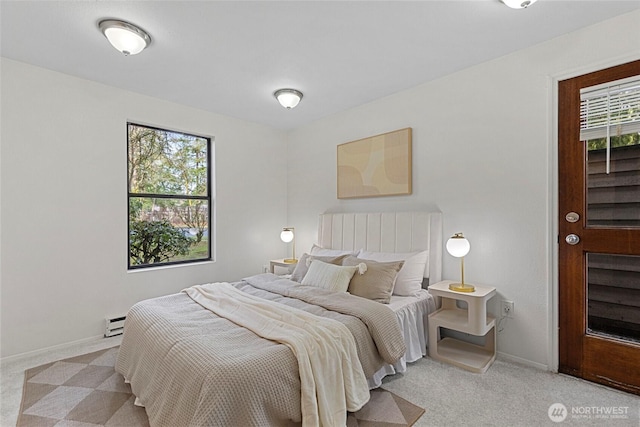 bedroom with a baseboard heating unit, multiple windows, and light colored carpet