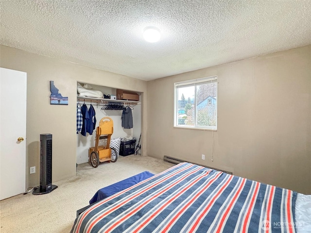 bedroom with baseboard heating, carpet flooring, a textured ceiling, and a closet