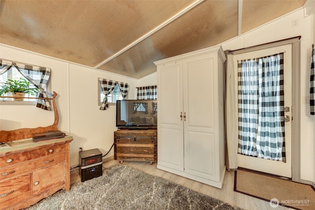 misc room with light wood-style flooring and lofted ceiling