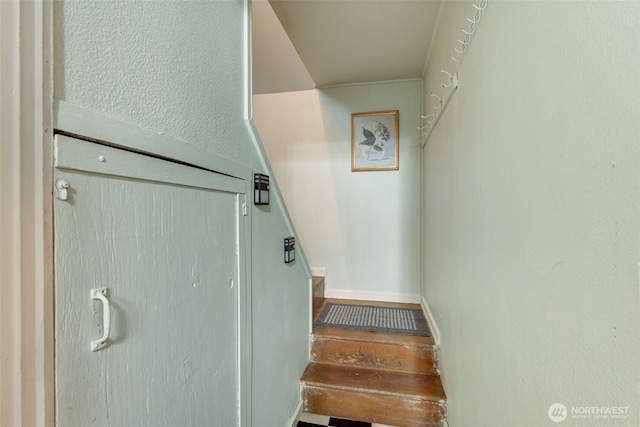 stairway with wood finished floors and baseboards