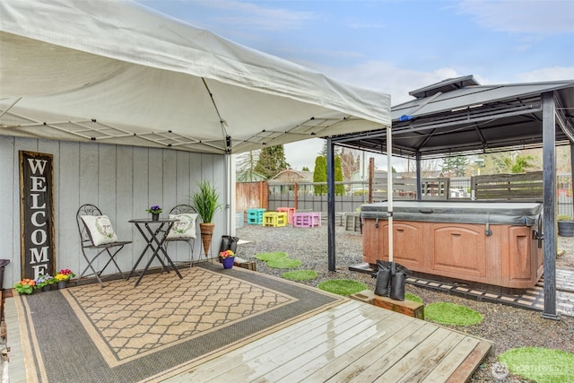 wooden terrace featuring a patio, a gazebo, fence, and a hot tub