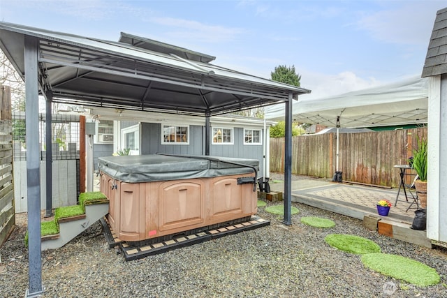 exterior space featuring a patio area, a gazebo, fence, and a hot tub