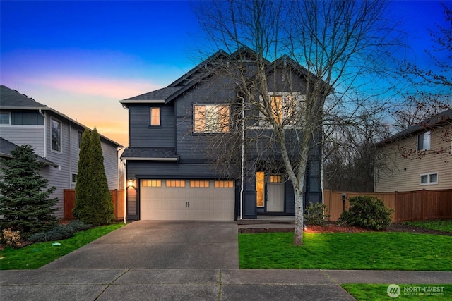 view of front of house with an attached garage, fence, a lawn, and driveway