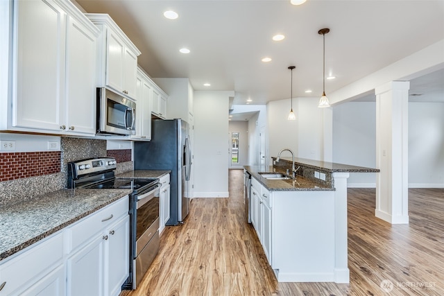 kitchen featuring a sink, decorative backsplash, light wood-style floors, and stainless steel appliances