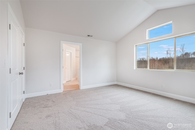 unfurnished bedroom featuring visible vents, ensuite bathroom, carpet, baseboards, and vaulted ceiling