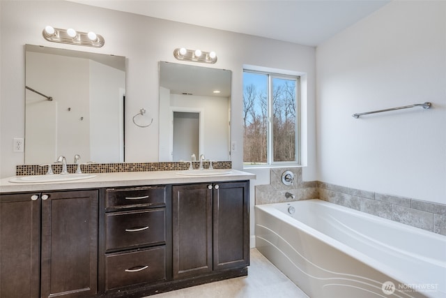 bathroom featuring double vanity, a garden tub, and a sink