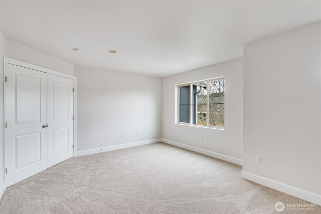 unfurnished bedroom with baseboards and light colored carpet