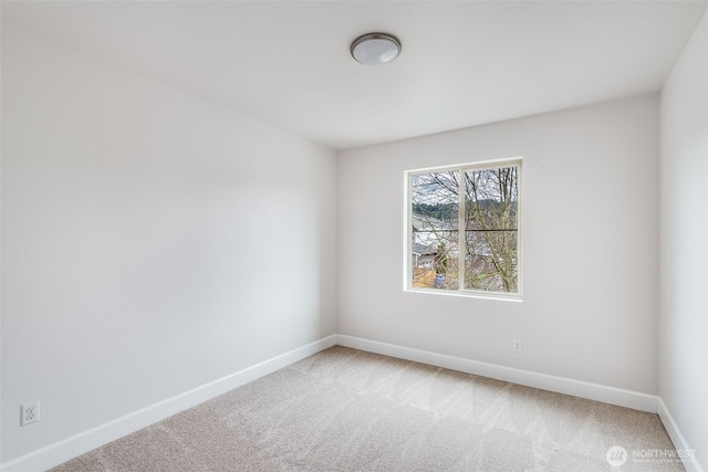 carpeted empty room featuring baseboards