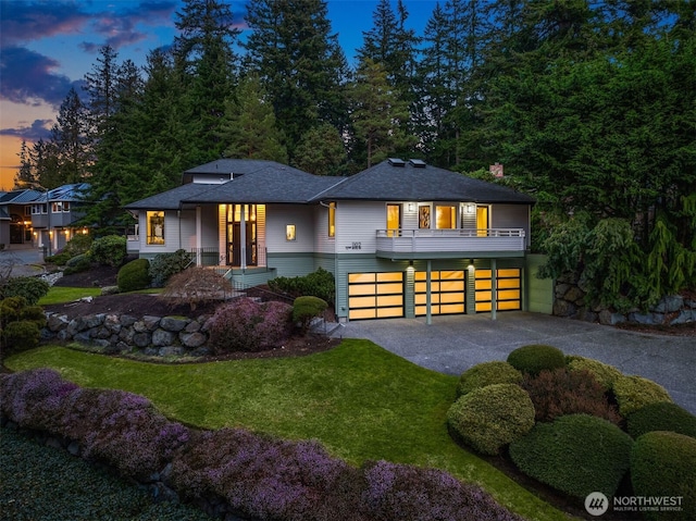 view of front of house featuring driveway, an attached garage, and a front yard