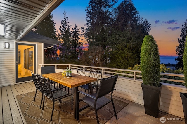 deck at dusk with outdoor dining area