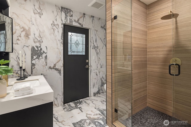 bathroom with visible vents, marble finish floor, a shower stall, and vanity