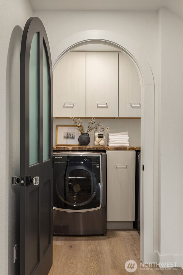 laundry room with washer / dryer, cabinet space, and light wood-style flooring