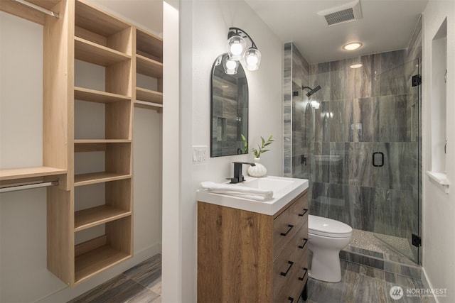 full bathroom featuring toilet, a shower stall, visible vents, and vanity