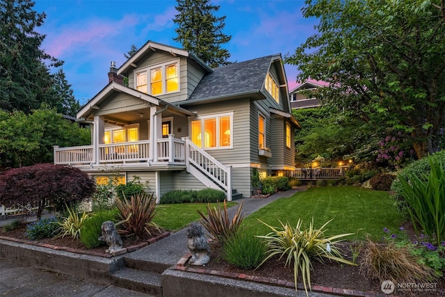 craftsman house with covered porch and a lawn