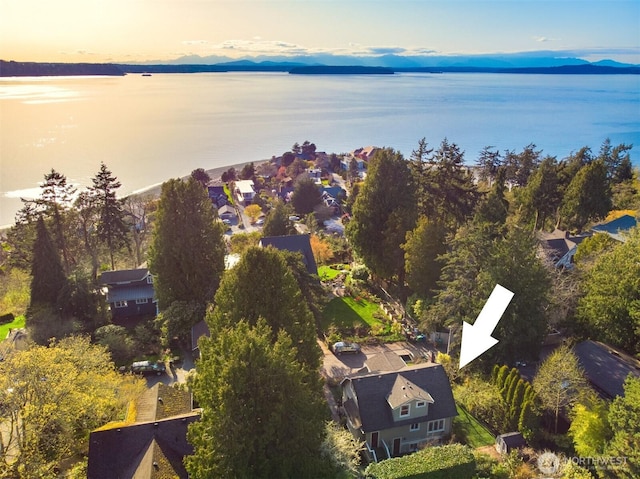 aerial view at dusk featuring a water view