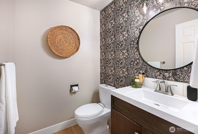 bathroom with hardwood / wood-style flooring, toilet, and vanity