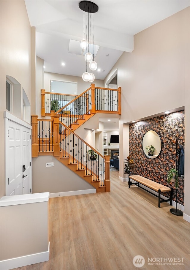 stairs featuring high vaulted ceiling, wood-type flooring, and beamed ceiling