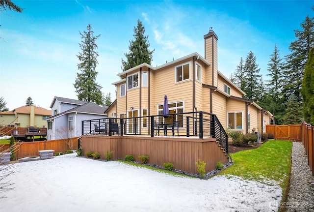 snow covered house with a deck