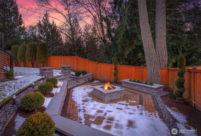 patio terrace at dusk featuring an outdoor fire pit