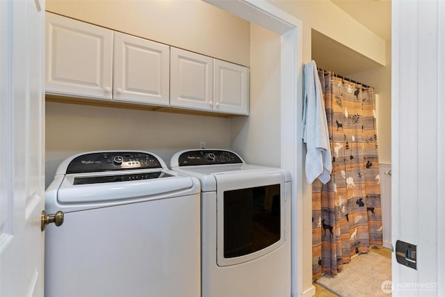 laundry room with separate washer and dryer and cabinets