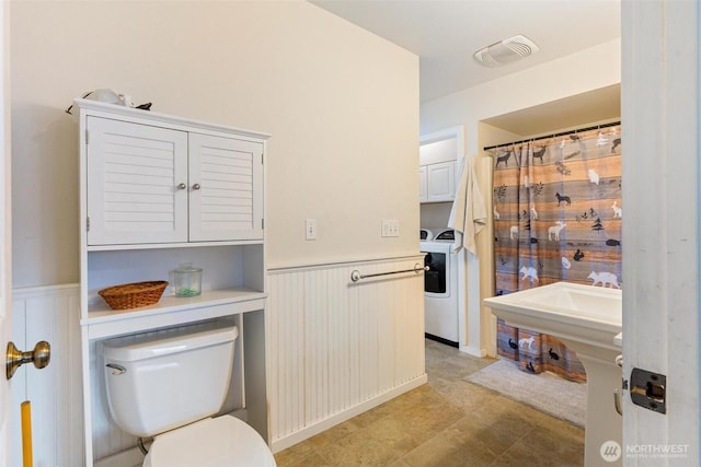 bathroom with washer / clothes dryer and toilet