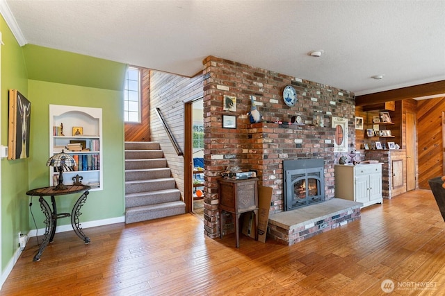 living room with a fireplace, light hardwood / wood-style floors, and a textured ceiling