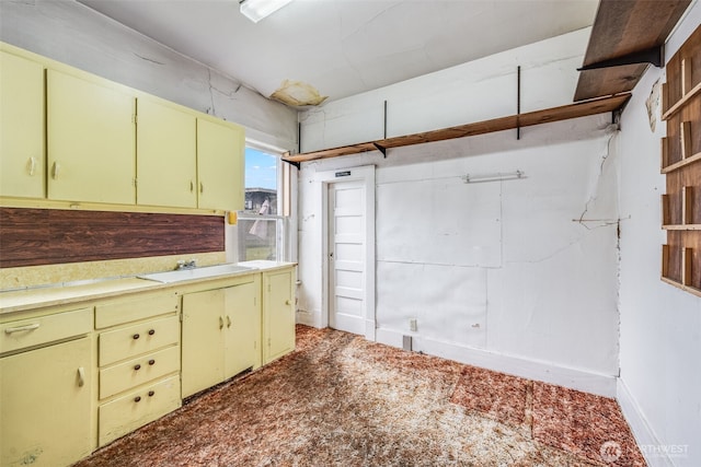 kitchen with open shelves, light countertops, and a sink