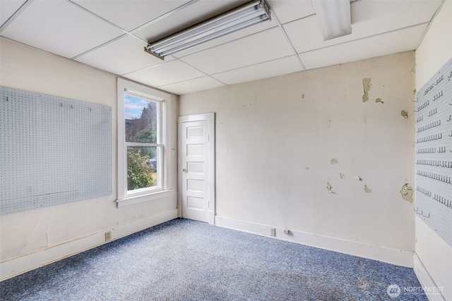 carpeted empty room featuring a paneled ceiling