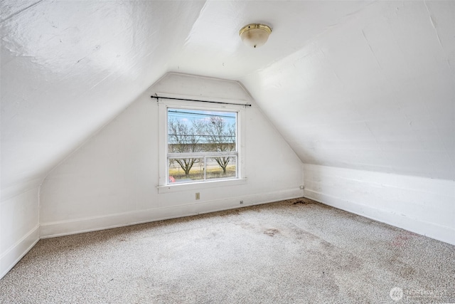 additional living space featuring vaulted ceiling, carpet flooring, and baseboards