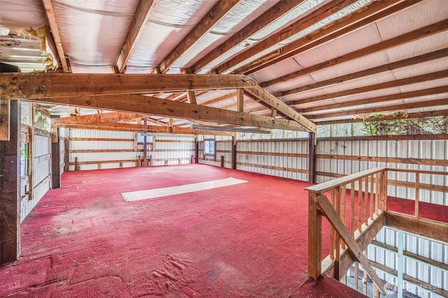 miscellaneous room featuring vaulted ceiling and metal wall