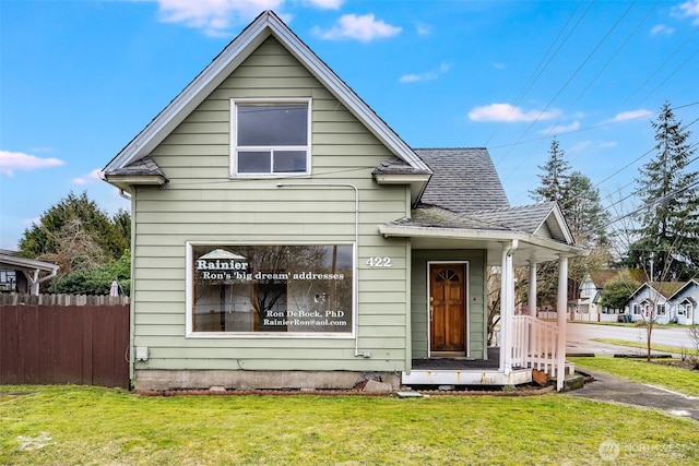 bungalow-style house featuring a shingled roof, a front yard, and fence