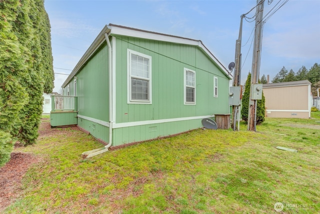 view of side of property with crawl space and a lawn