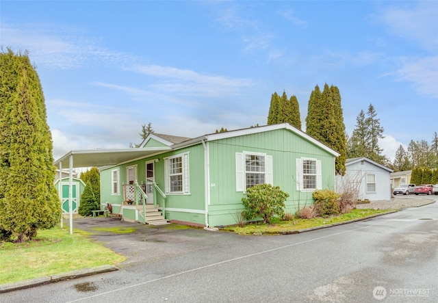 manufactured / mobile home featuring driveway, an attached carport, and crawl space