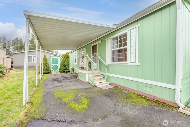 view of patio / terrace with a storage shed, an attached carport, and an outdoor structure