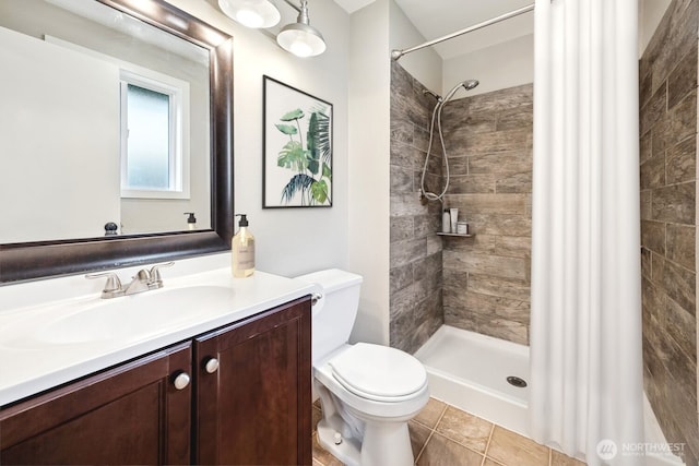 bathroom featuring toilet, a shower stall, tile patterned flooring, and vanity