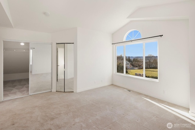 unfurnished bedroom featuring vaulted ceiling, carpet floors, visible vents, and baseboards