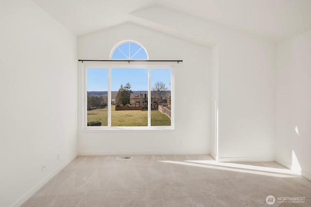 carpeted empty room with lofted ceiling and visible vents