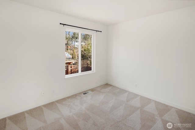 unfurnished room featuring carpet floors, visible vents, and baseboards