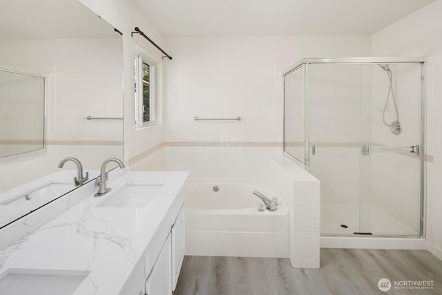 full bathroom featuring a garden tub, a shower stall, wood finished floors, and vanity