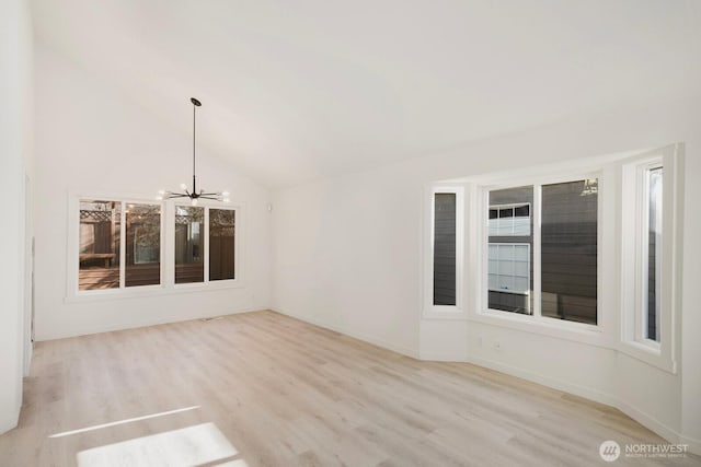 interior space with vaulted ceiling, baseboards, wood finished floors, and a notable chandelier